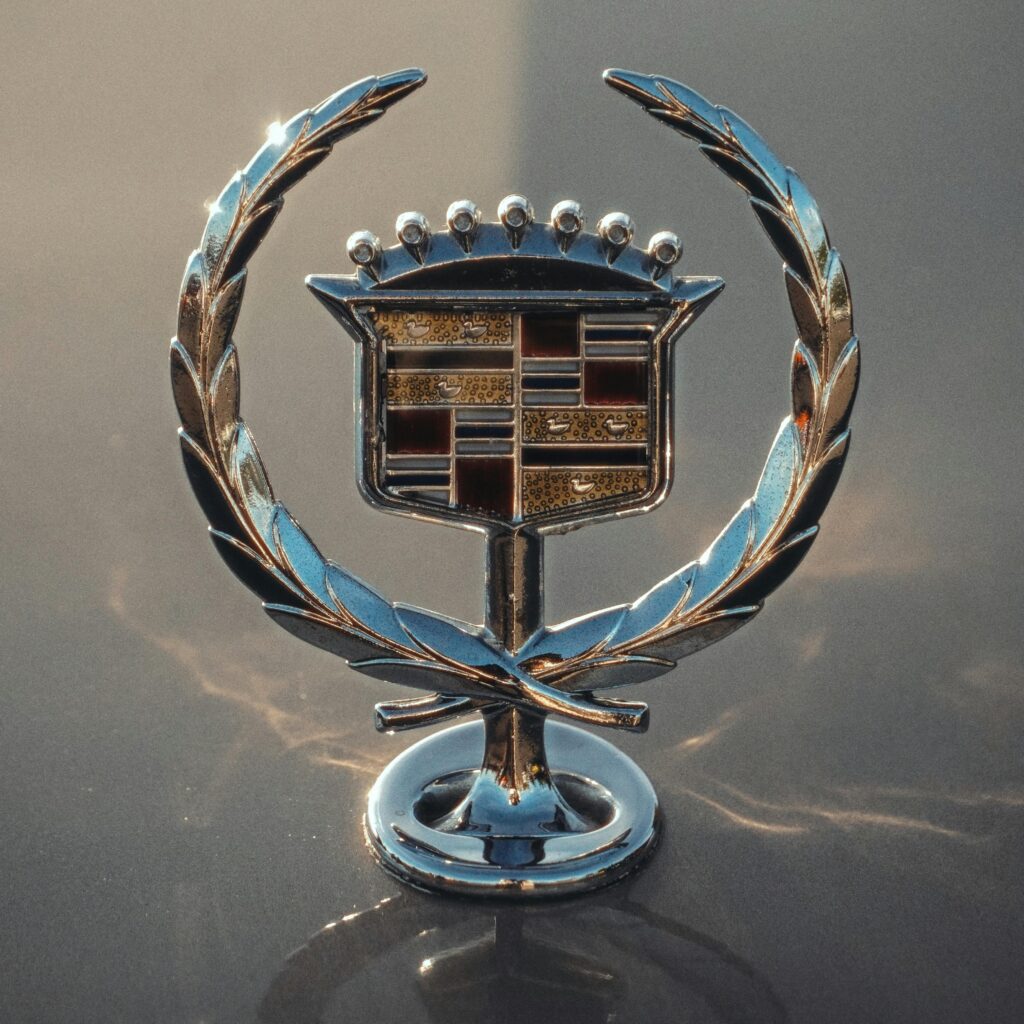 A detailed shot of a classic vintage car emblem, highlighting its reflective chrome finish.