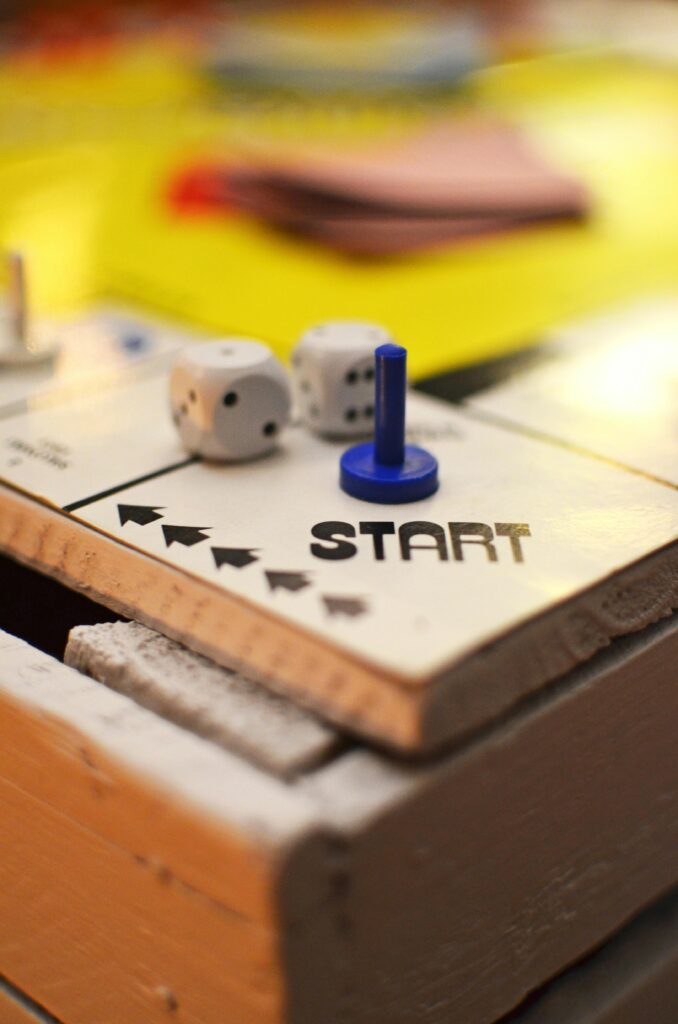 Close-up of a board game start position featuring dice and a blue game piece, perfect for leisure themes.